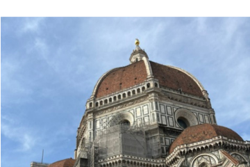 The dome of the Cathedral of Santa Maria del Fiore (The Duomo) rising beneath a bright blue sky in Florence, Italy.